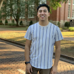 A Family and Consumer Sciences student smiles on the bricks near Wills Hall.