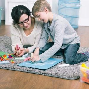 Single mother spending time with his son. Drawing together a picture